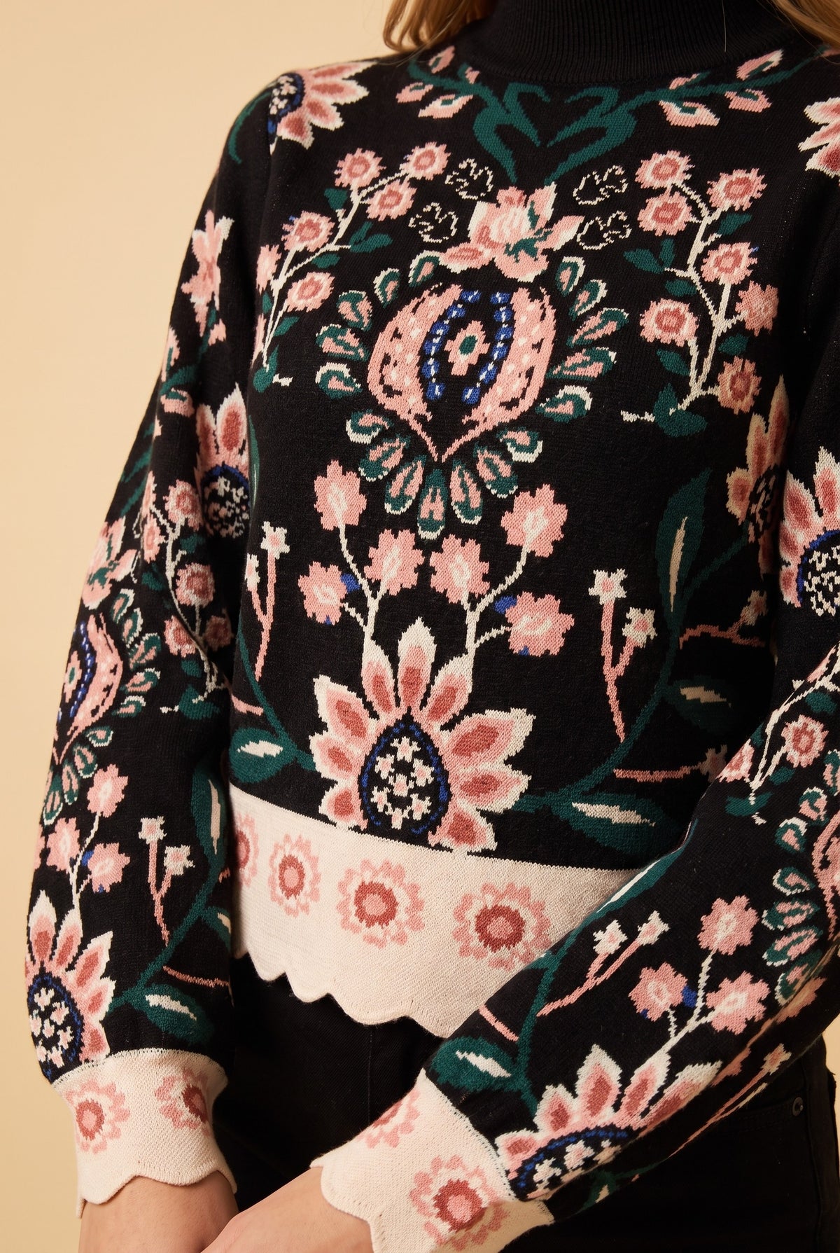 Close-up of the black floral jacquard high neck sweater showing the fabric and finishing details.