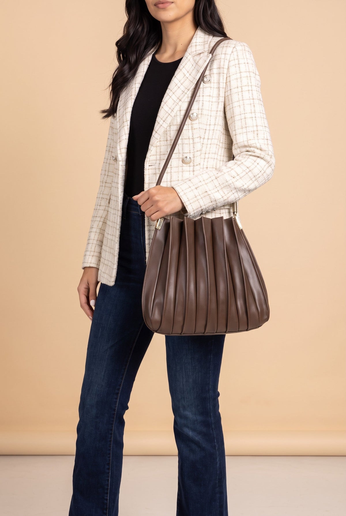 The Carrie pleated shoulder bag in chocolate pleated shoulder bag carried at the hip.