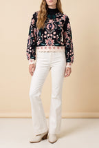 Front view of the black floral jacquard high neck sweater showing the fit and length.