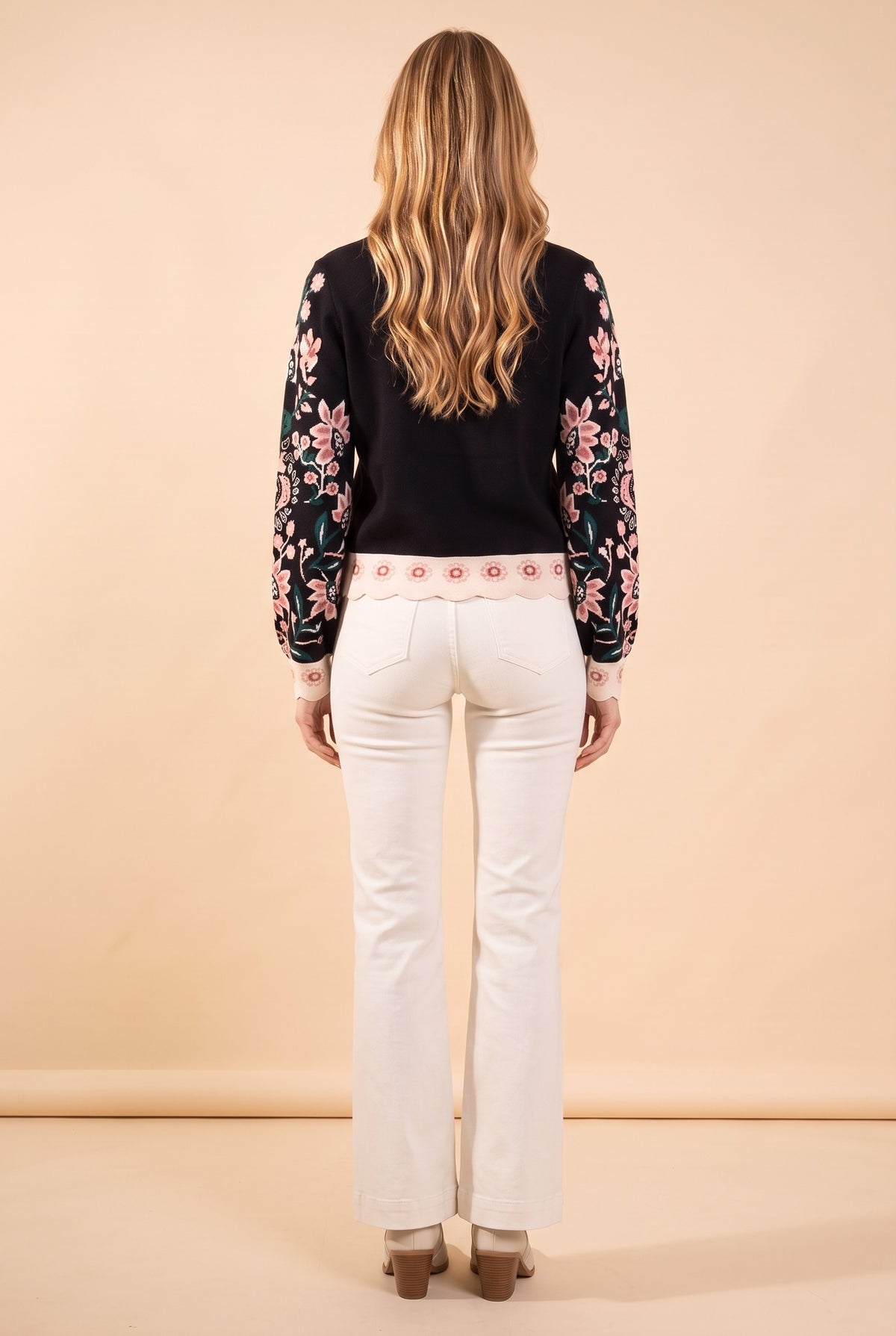 Back view of the black floral jacquard high neck sweater.