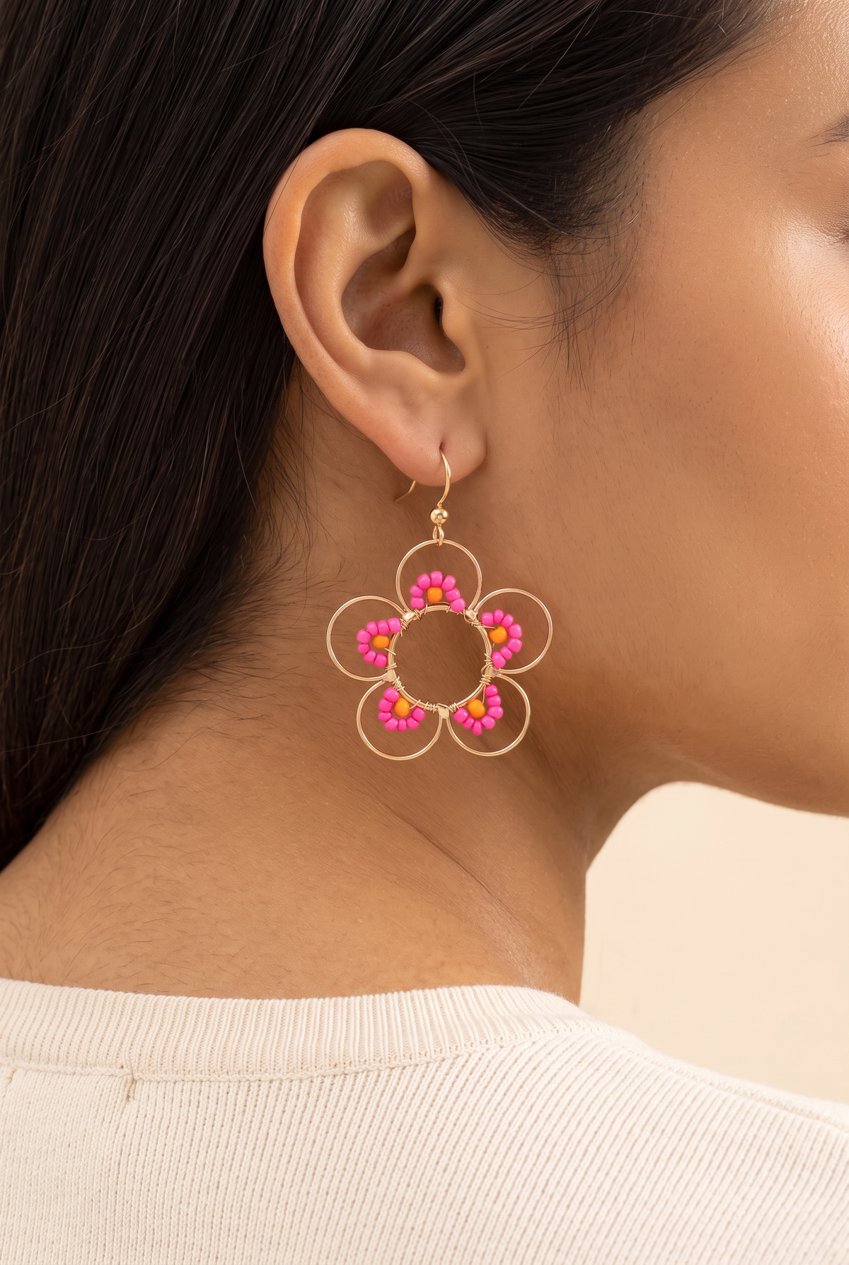 Daisy Earrings in Hot Pink worn on the ear at true size: the open gold wire flower is about 4 cm across and hangs just below the earlobe