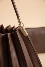 Close view of the Carrie pleated shoulder bag in chocolate pleated shoulder bag showing the material and details.