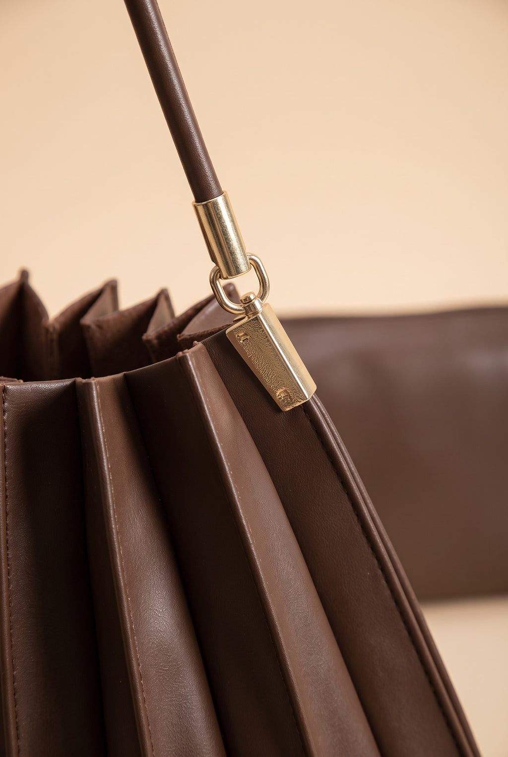 Close view of the Carrie chocolate pleated shoulder bag showing the material and details.
