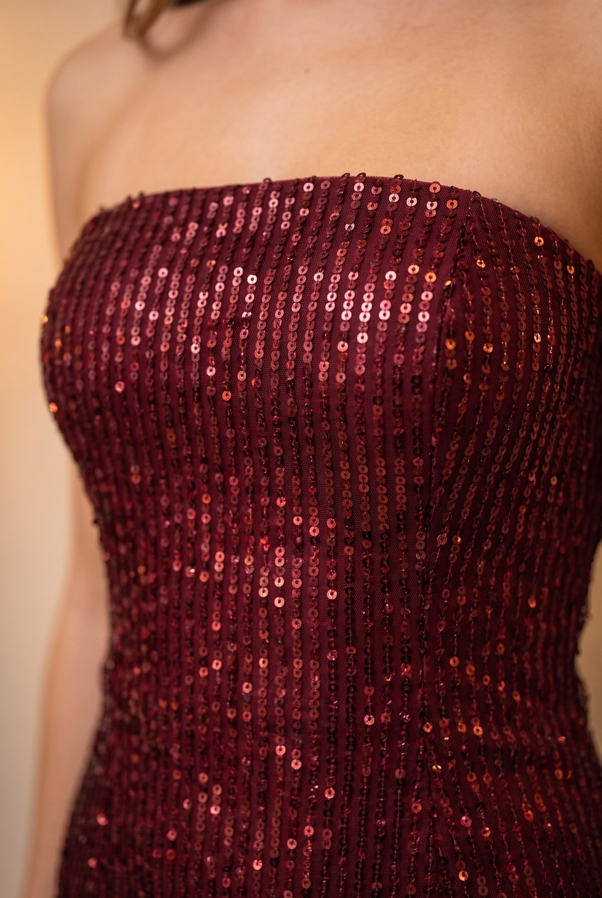 Close-up of the wine red strapless sequin mini dress showing the sequins and finishing details.
