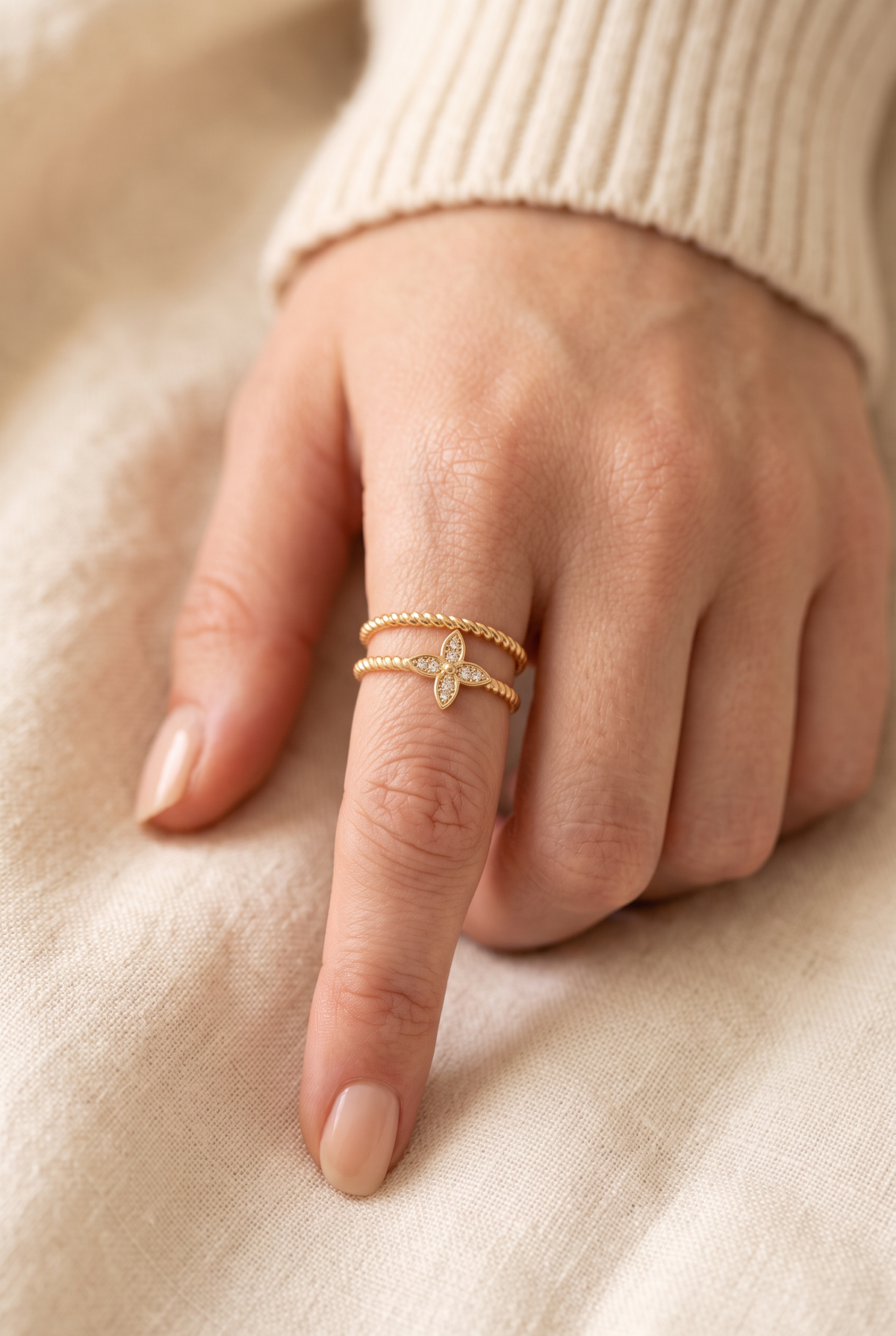 Nia Double Ring worn on the index finger at true size: two fine rope bands and a tiny stone-set flower
