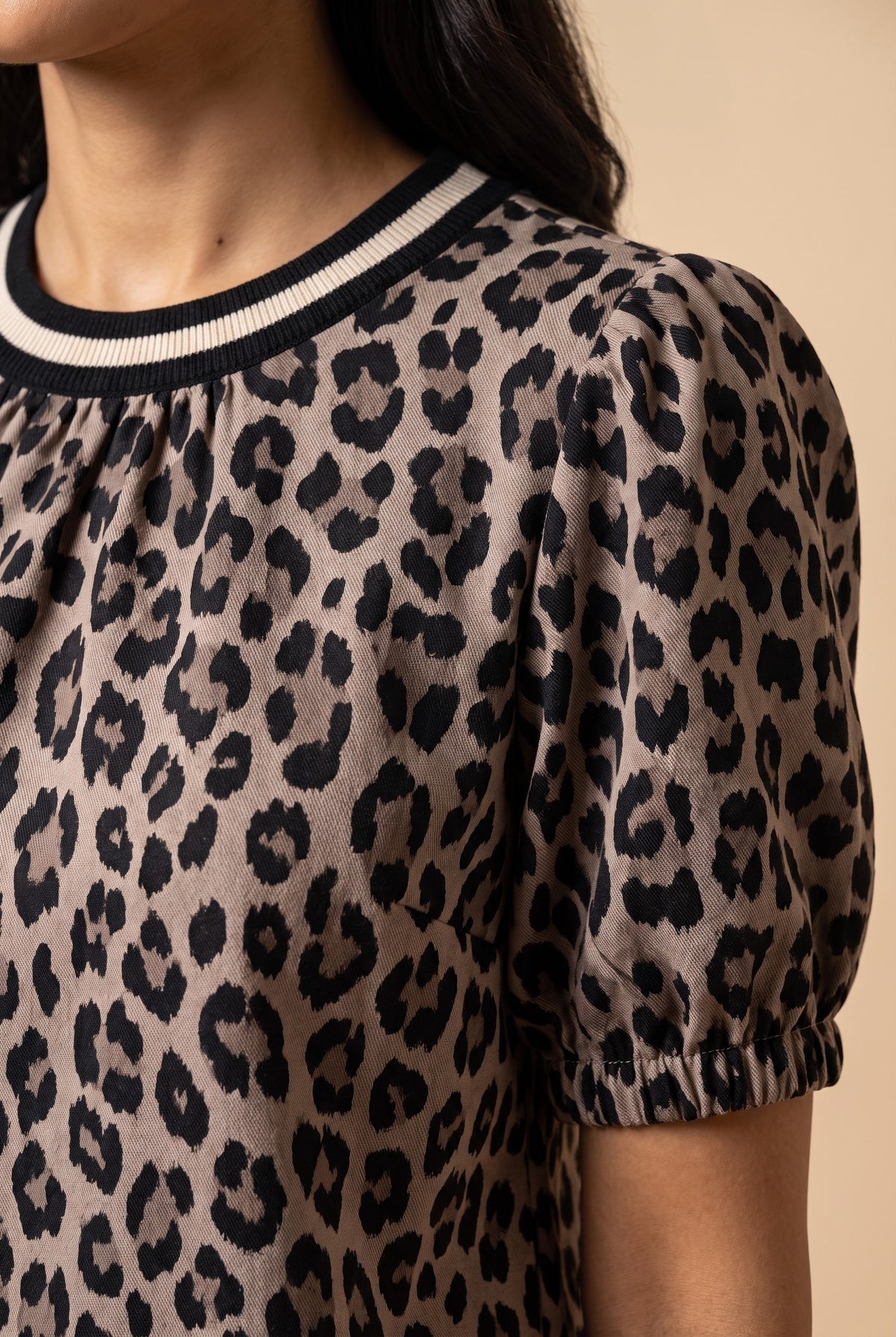 Close-up of the taupe leopard puff sleeve top showing the fabric and details.