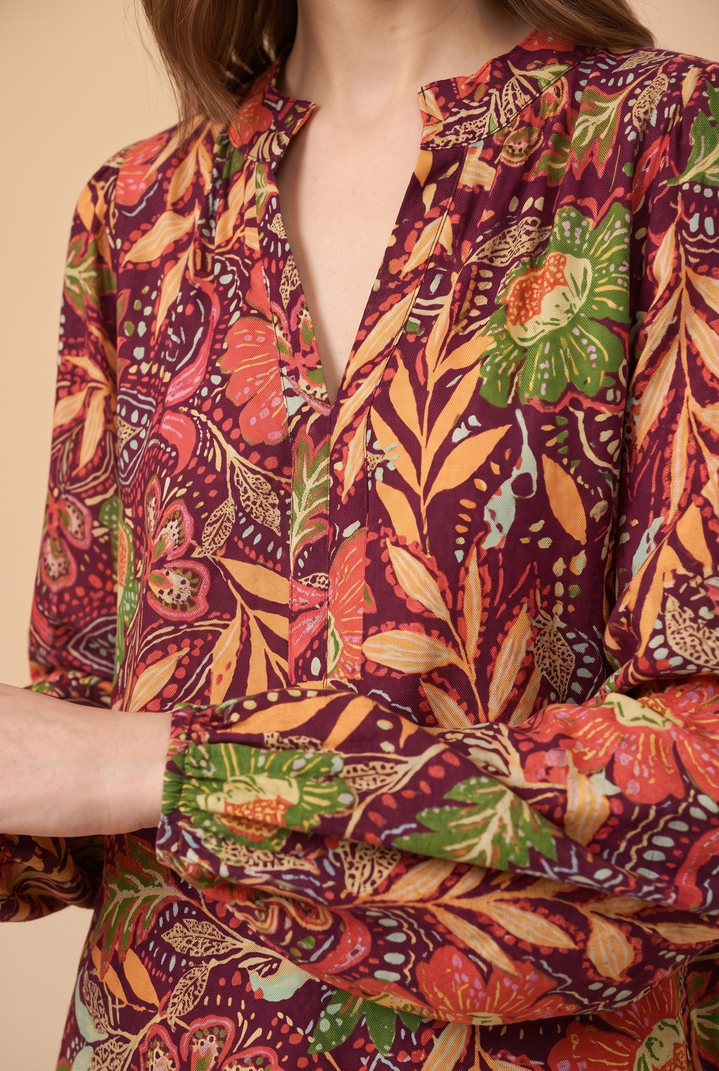 Close-up of the burgundy floral split neck blouse showing the fabric and details.