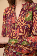 Close-up of the burgundy floral split neck blouse showing the fabric and details.