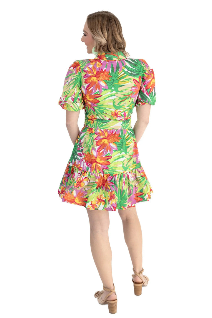 A model wearing a vibrant tropical floral print puff sleeve shirt dress with a self-tie waist and ruffle hem, perfect for vacations and summer outings.