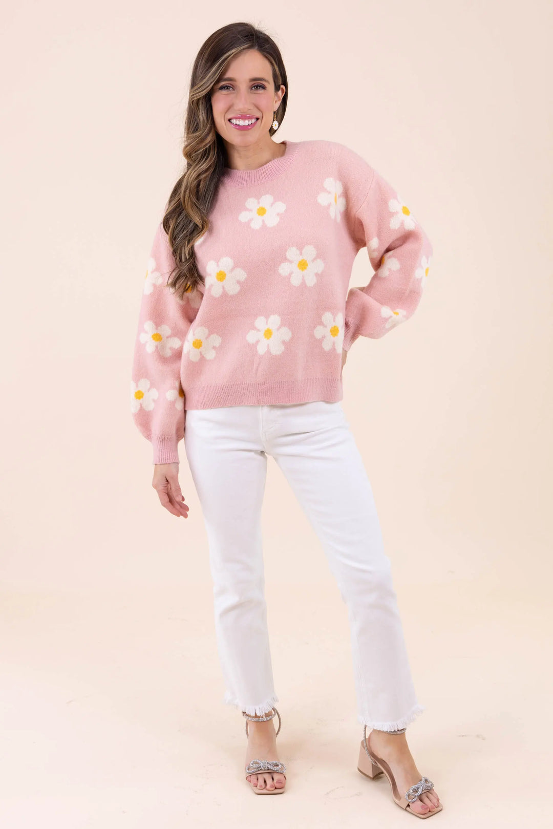 Blush pink knit sweater with white daisy floral pattern, featuring a crew neckline and balloon sleeves for a cozy and stylish look.