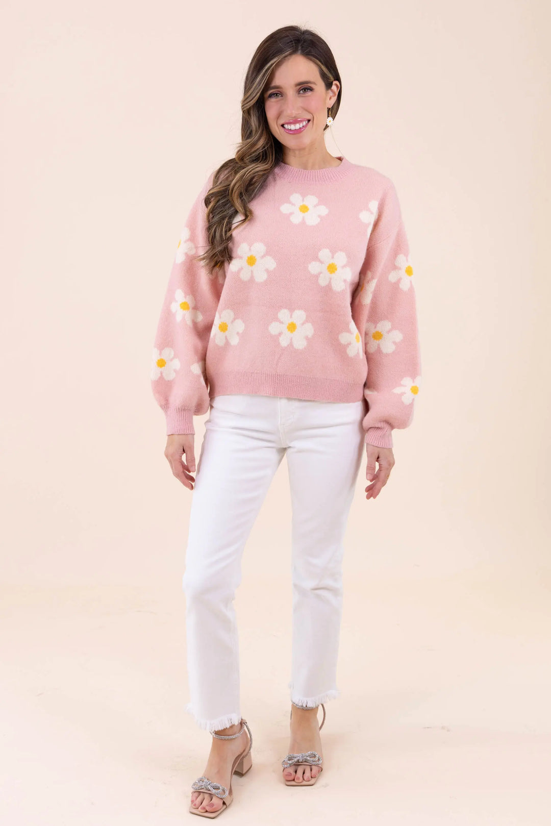 Blush pink knit sweater with white daisy floral pattern, featuring a crew neckline and balloon sleeves for a cozy and stylish look.