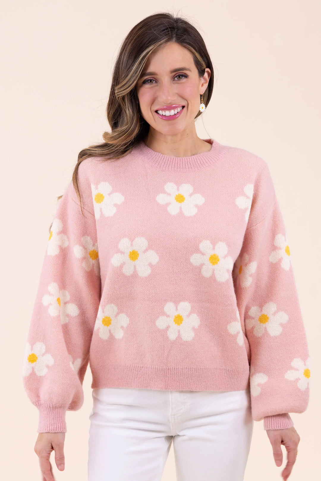 Blush pink knit sweater with white daisy floral pattern, featuring a crew neckline and balloon sleeves for a cozy and stylish look.