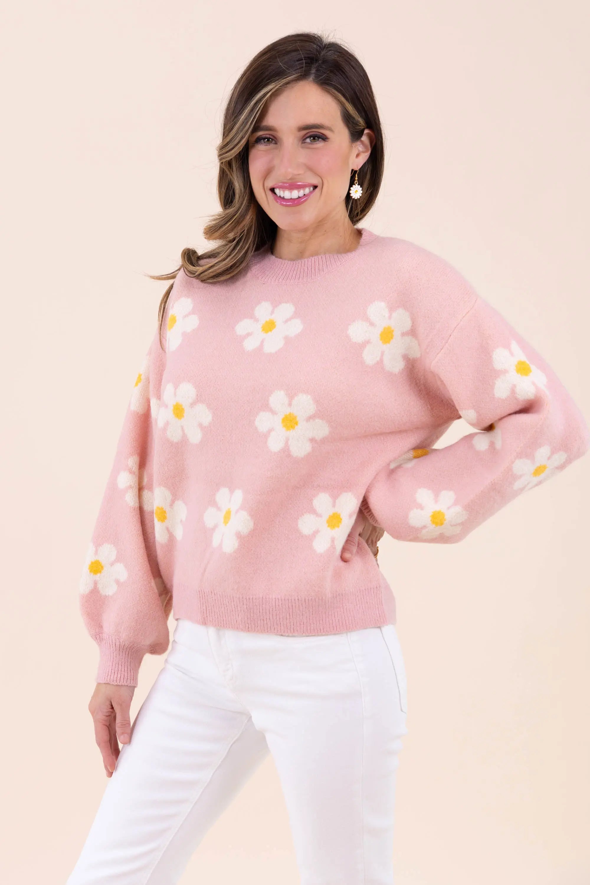 Blush pink knit sweater with white daisy floral pattern, featuring a crew neckline and balloon sleeves for a cozy and stylish look.