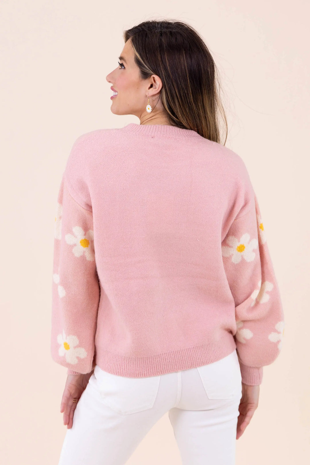 Blush pink knit sweater with white daisy floral pattern, featuring a crew neckline and balloon sleeves for a cozy and stylish look.