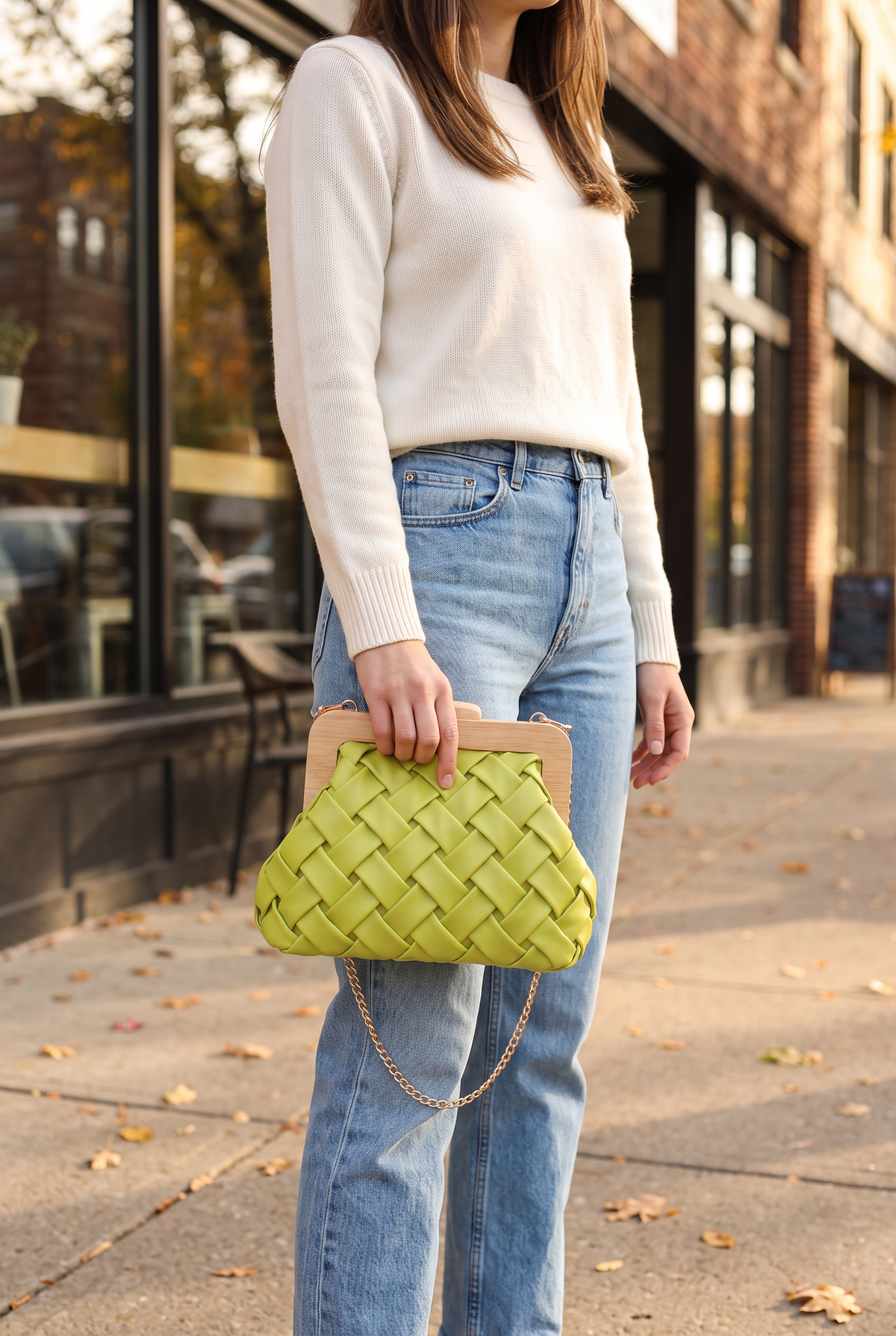 Nova Woven Clutch in Lime held in one hand at the hip, shown at its true 8.6 inch width