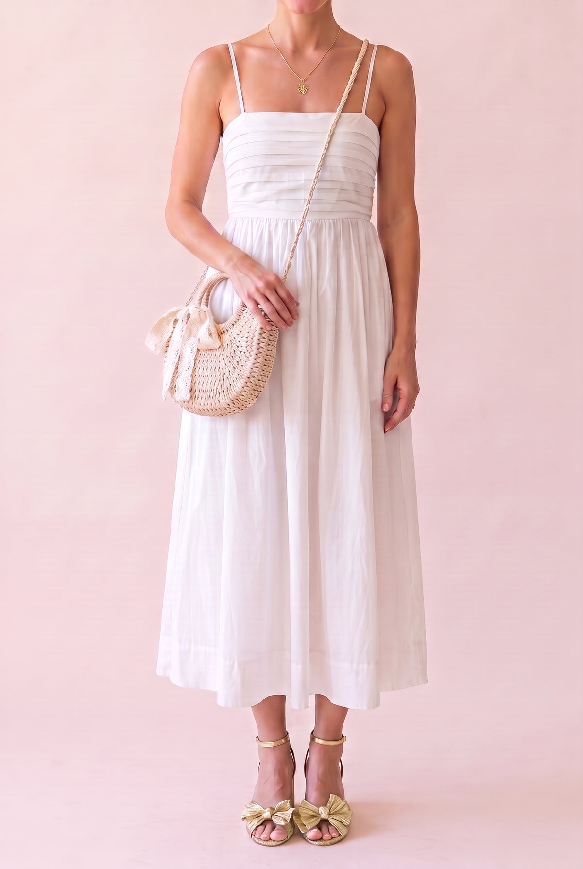 Marina Palm Leaf Necklace (small gold monstera leaf pendant) worn at true size with the Love Actually White Pleated Midi Dress, Avery Bow Sandals and Rose Crochet Lace Rattan Wicker Crossbody Bag, shown from the chin down