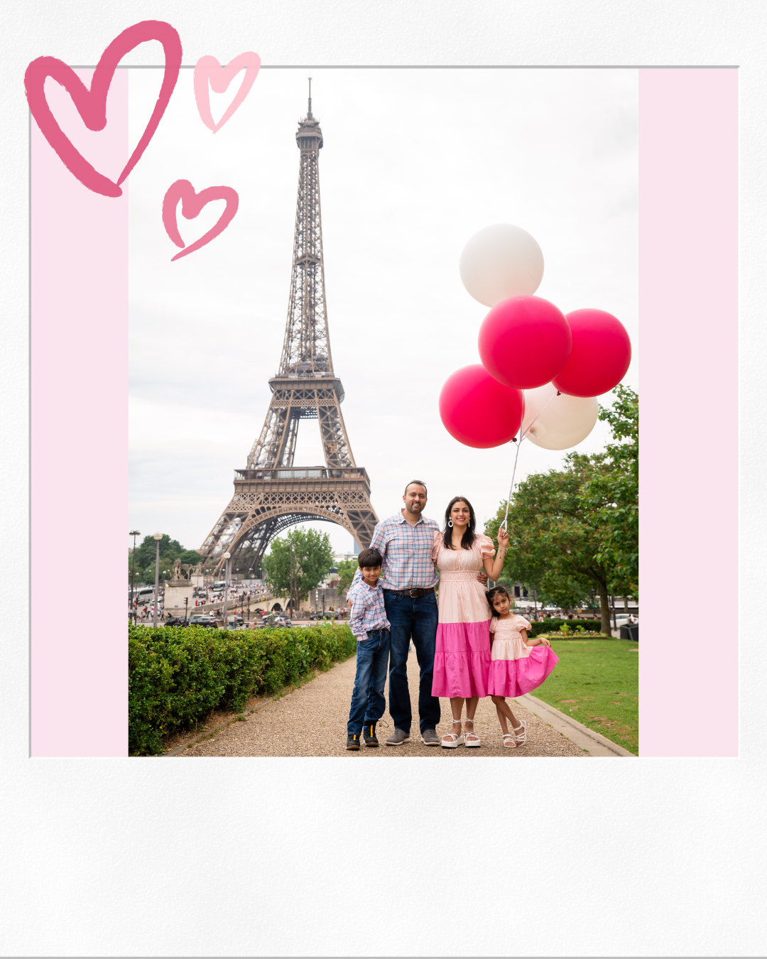 Shweta with her husband and their son and daughter in front of the Eiffel Tower, holding pink and white balloons