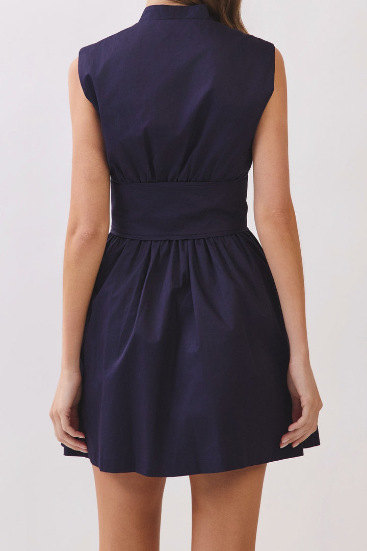 Back of the navy fit and flare mini dress, showing the stand collar, wide waist band and gathered skirt