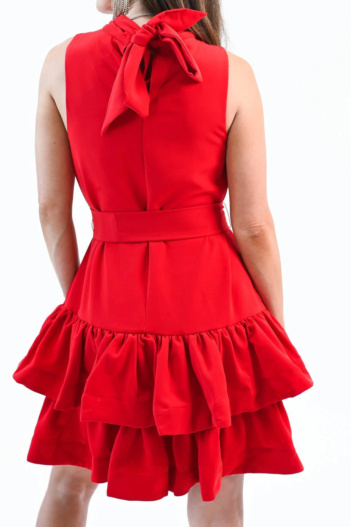 Back of the red ruffle tiered mini dress, showing the bow tie at the back neck, the sash and the ruffled tiers