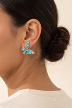 June Butterfly Earrings in Turquoise worn on the earlobe at true size: a small half-butterfly stud about 1 in across