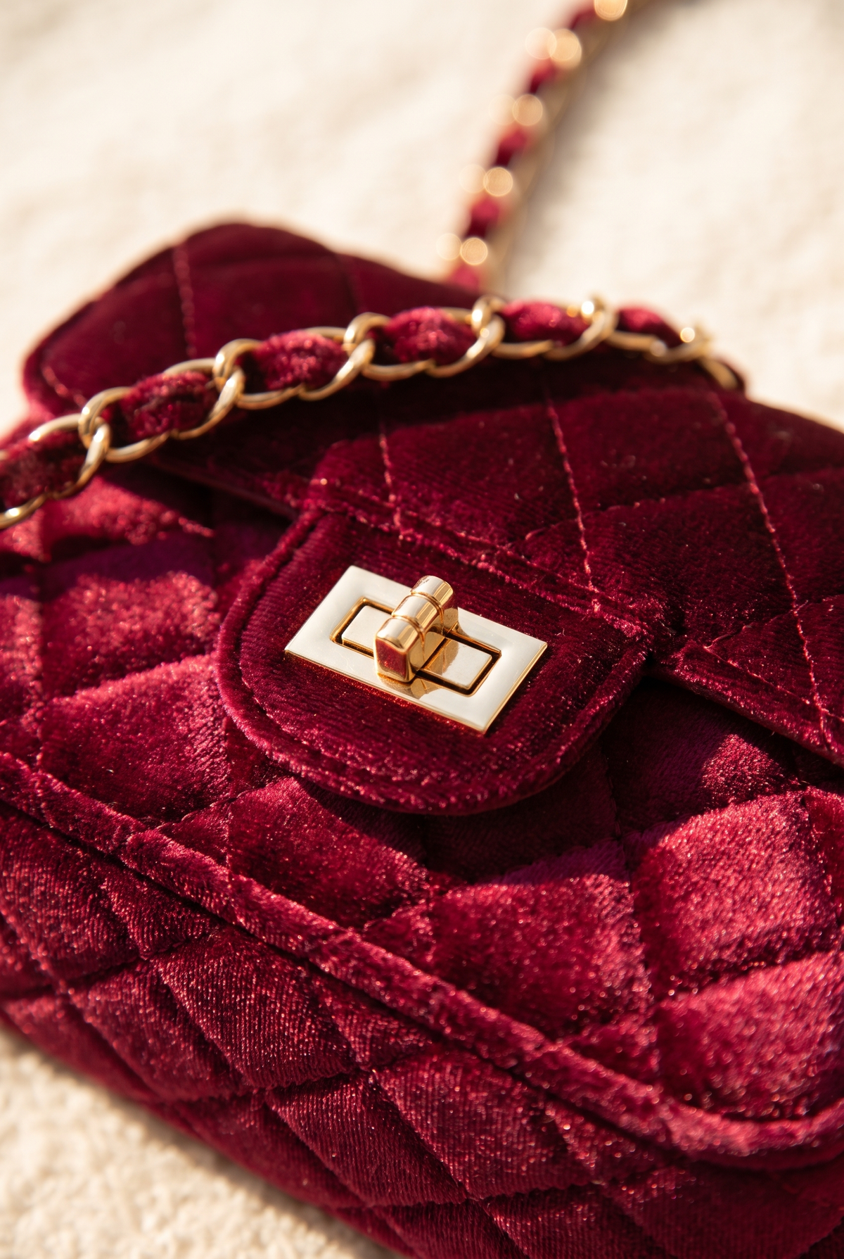 Close-up of the burgundy velvet bag's quilting and hardware
