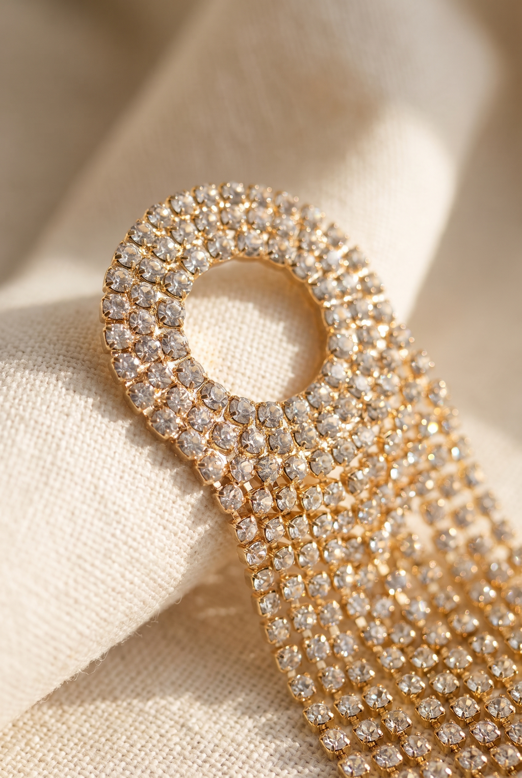 Close-up of the Nancy earring's gold fringe chains and stud