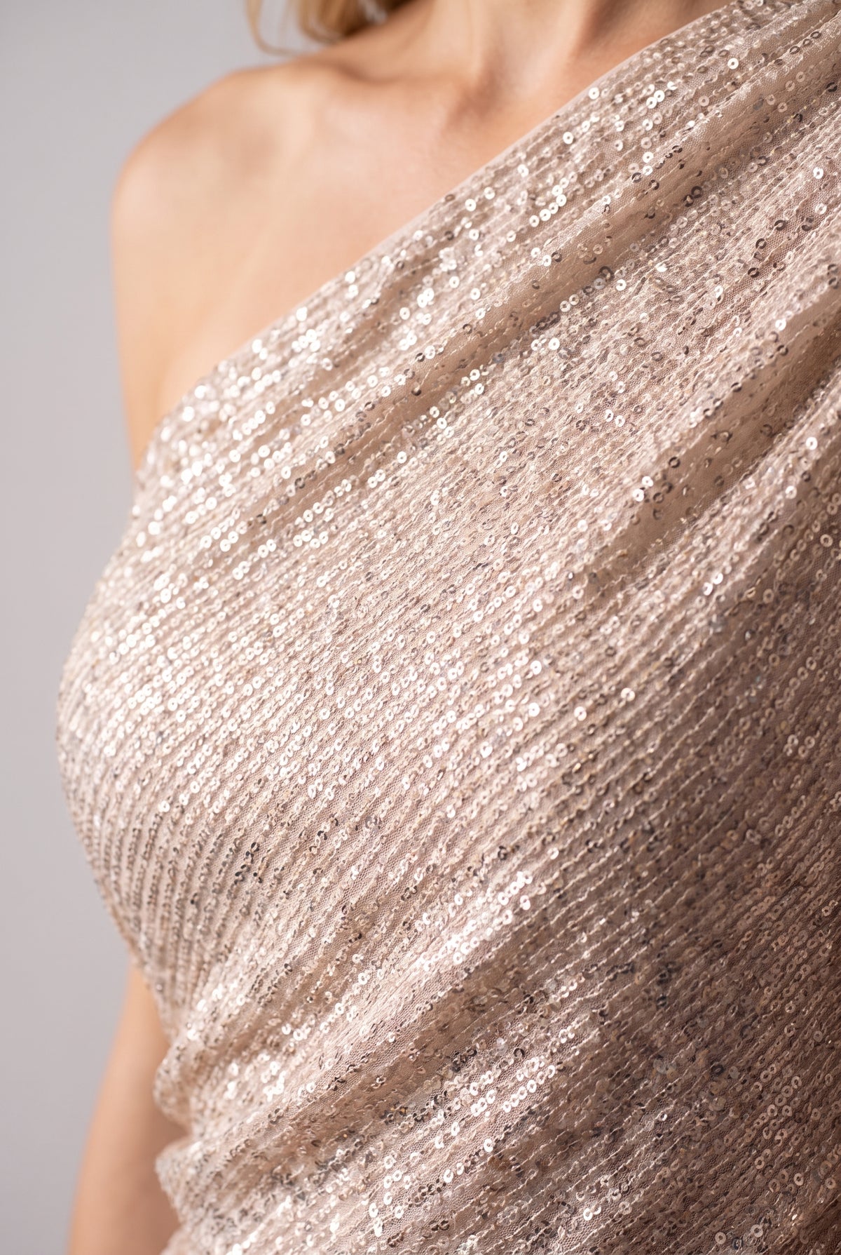 Close-up of the sequins and the one-shoulder neckline of the sequin top