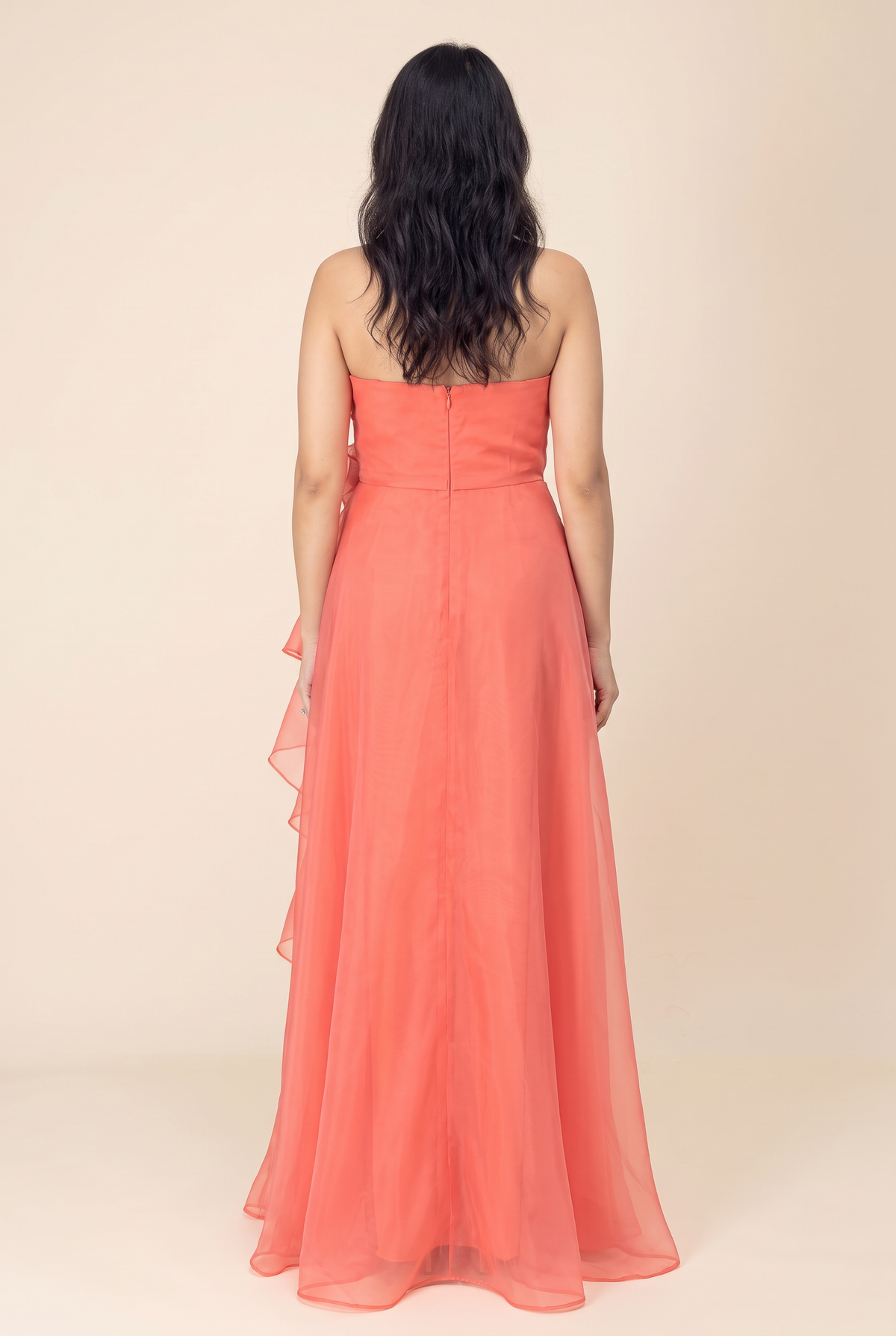 Back view of the coral organza maxi dress showing the smooth strapless bodice, center back zipper and soft layered skirt