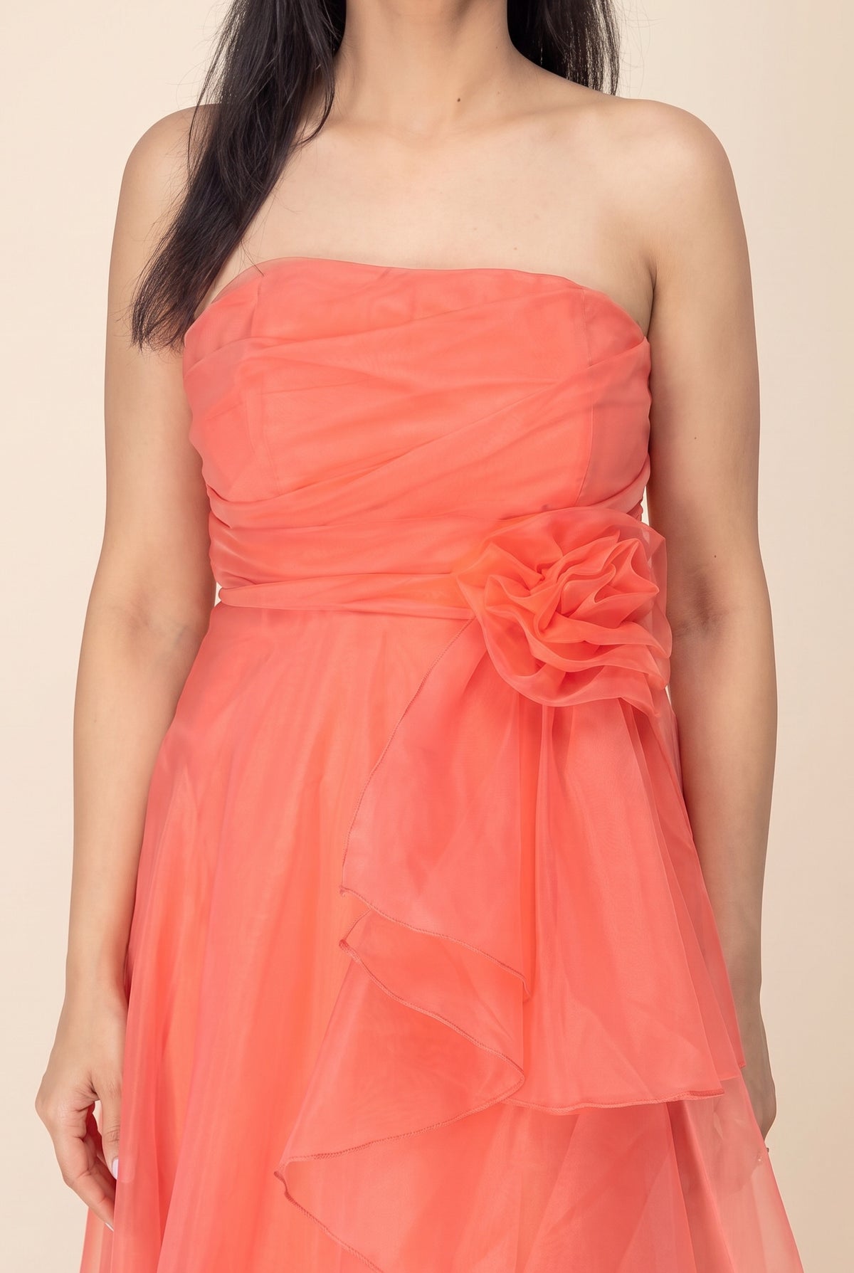 Close-up of the coral organza bodice ruching, waist rosette and sheer rolled-edge ruffles