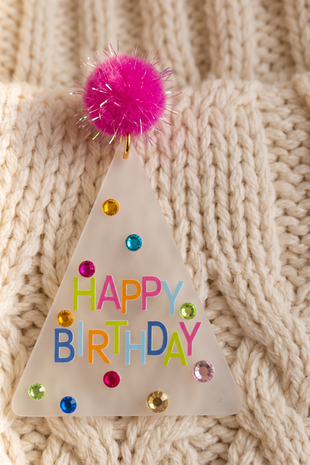 Close-up of one Dorothy Make A Wish Earring: frosted acrylic, printed HAPPY BIRTHDAY letters and faceted rhinestones