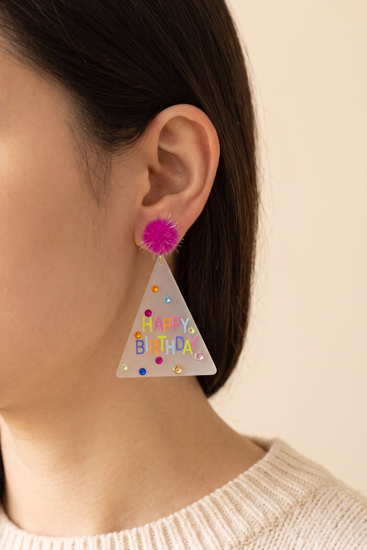 Dorothy Make A Wish Earring worn, showing its true size: the party hat hangs about as long as the ear, just past the jawline