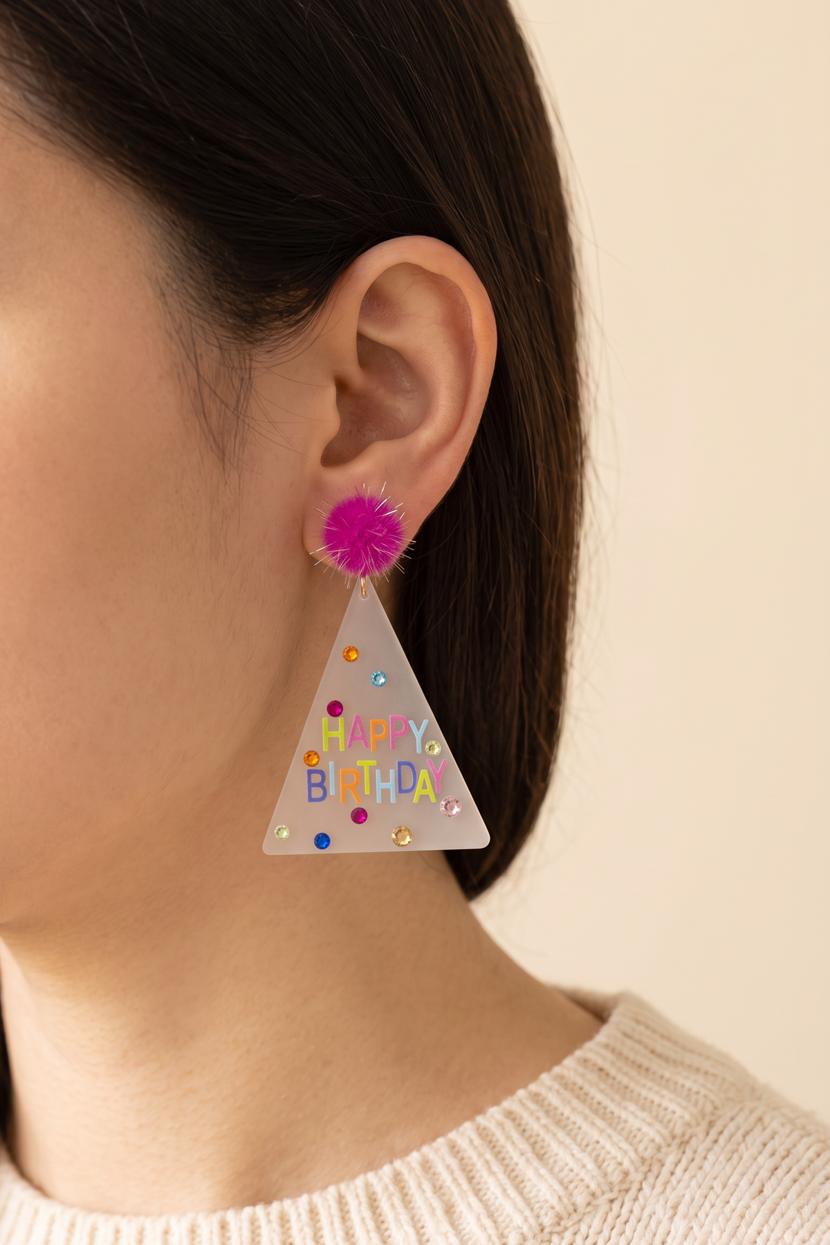 Dorothy Make A Wish Earring worn, showing its true size: the party hat hangs about as long as the ear, just past the jawline