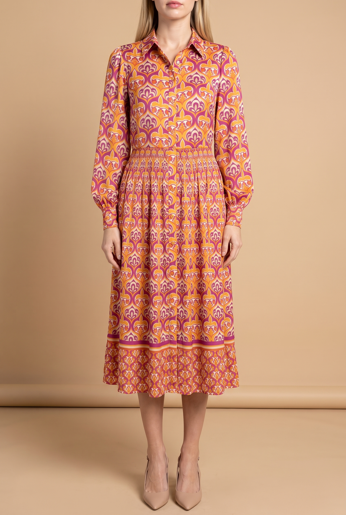 Front view of the I'm Spicing Things Up printed midi shirt dress on a beige studio backdrop: collar, button front, blouson sleeves, smocked waist and border-print hem at mid-calf.