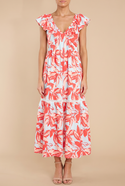 Front view of the Painted The Sky floral maxi dress on a beige studio backdrop: ruffle-edged V-neck, flutter sleeves, lace-trimmed tiers, ankle-length hem.