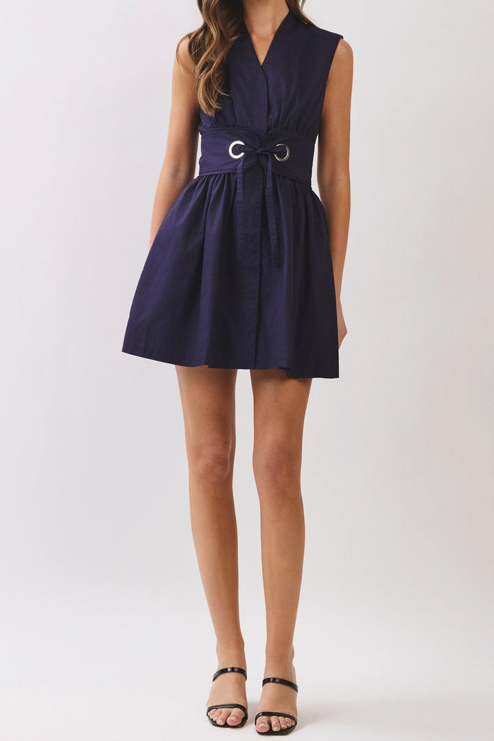Front of the Midnight Blue belted mini dress, showing the V neckline with a small stand collar, wide waist band with silver grommet tie and full skirt at upper thigh