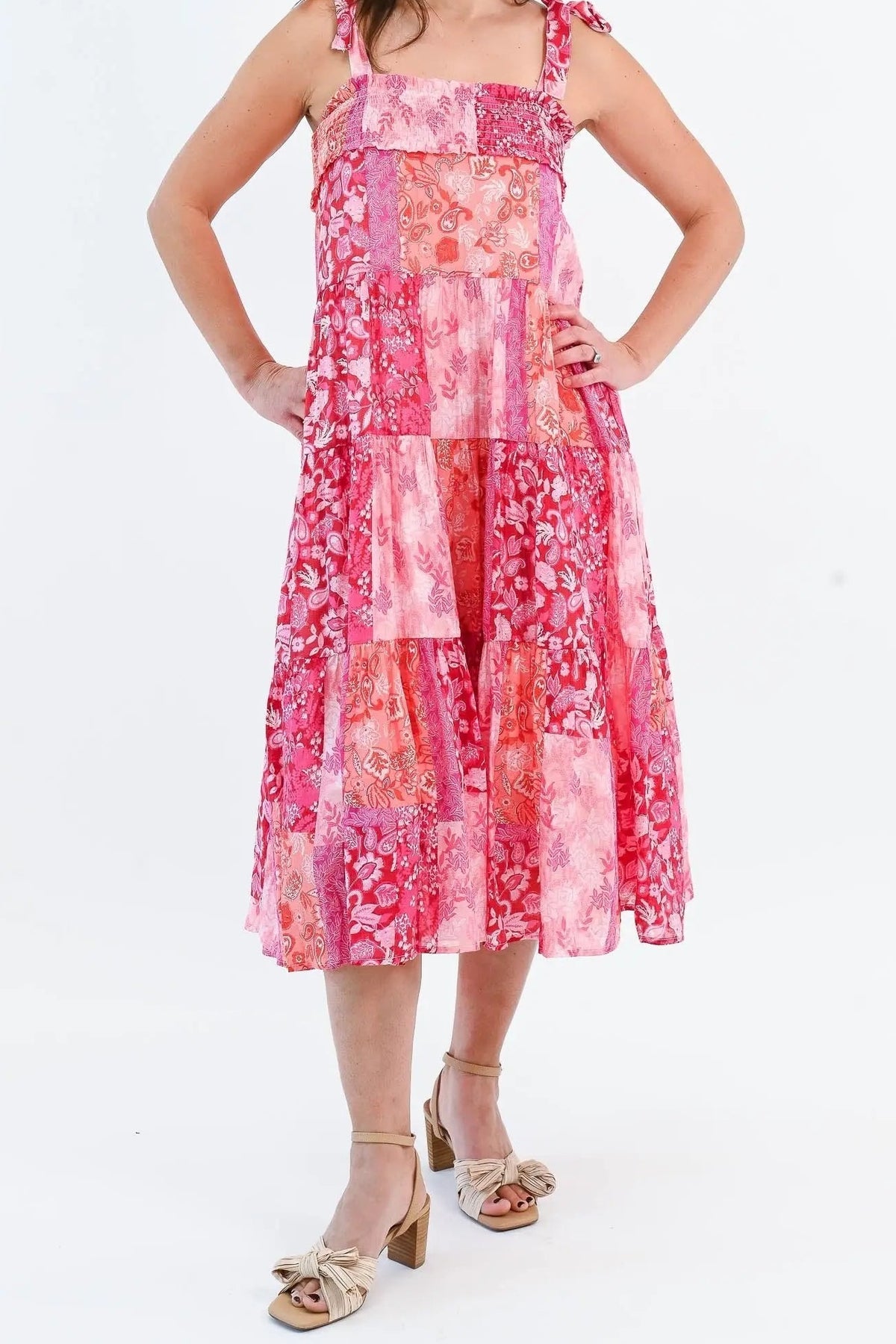 Front of the What's Next pink patchwork midi dress, showing the smocked straight bodice, shoulder tie straps and tiered skirt to mid-calf