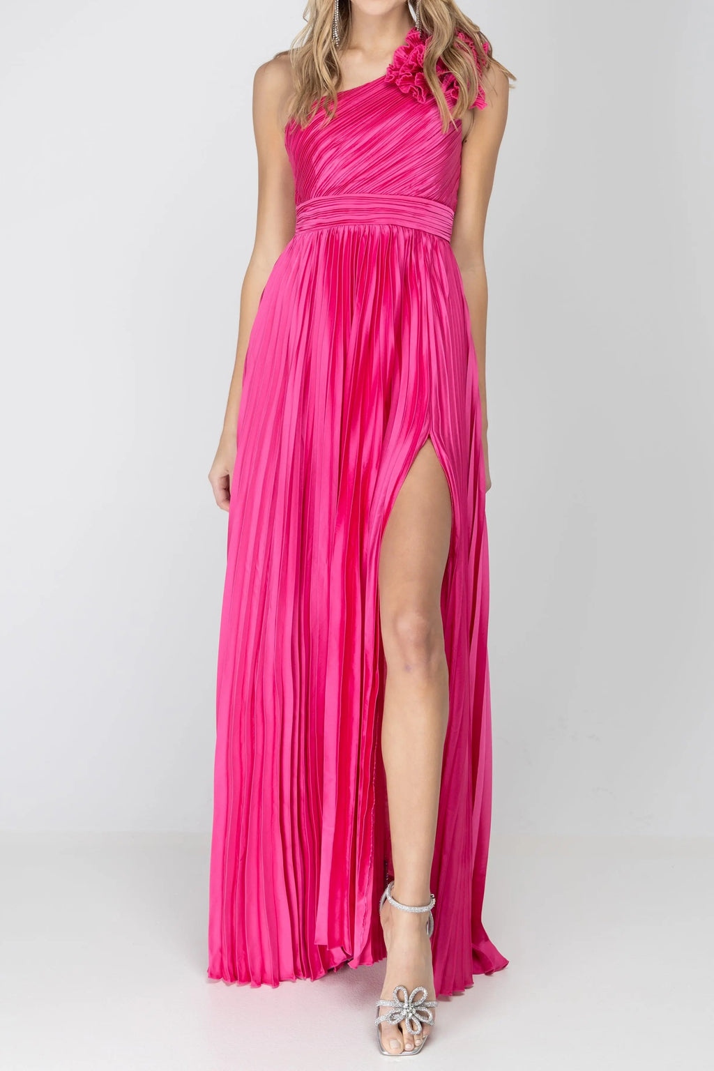 Front of the One More Night maxi dress in Fuchsia, showing the one-shoulder pleated bodice, shoulder rosette and high leg slit