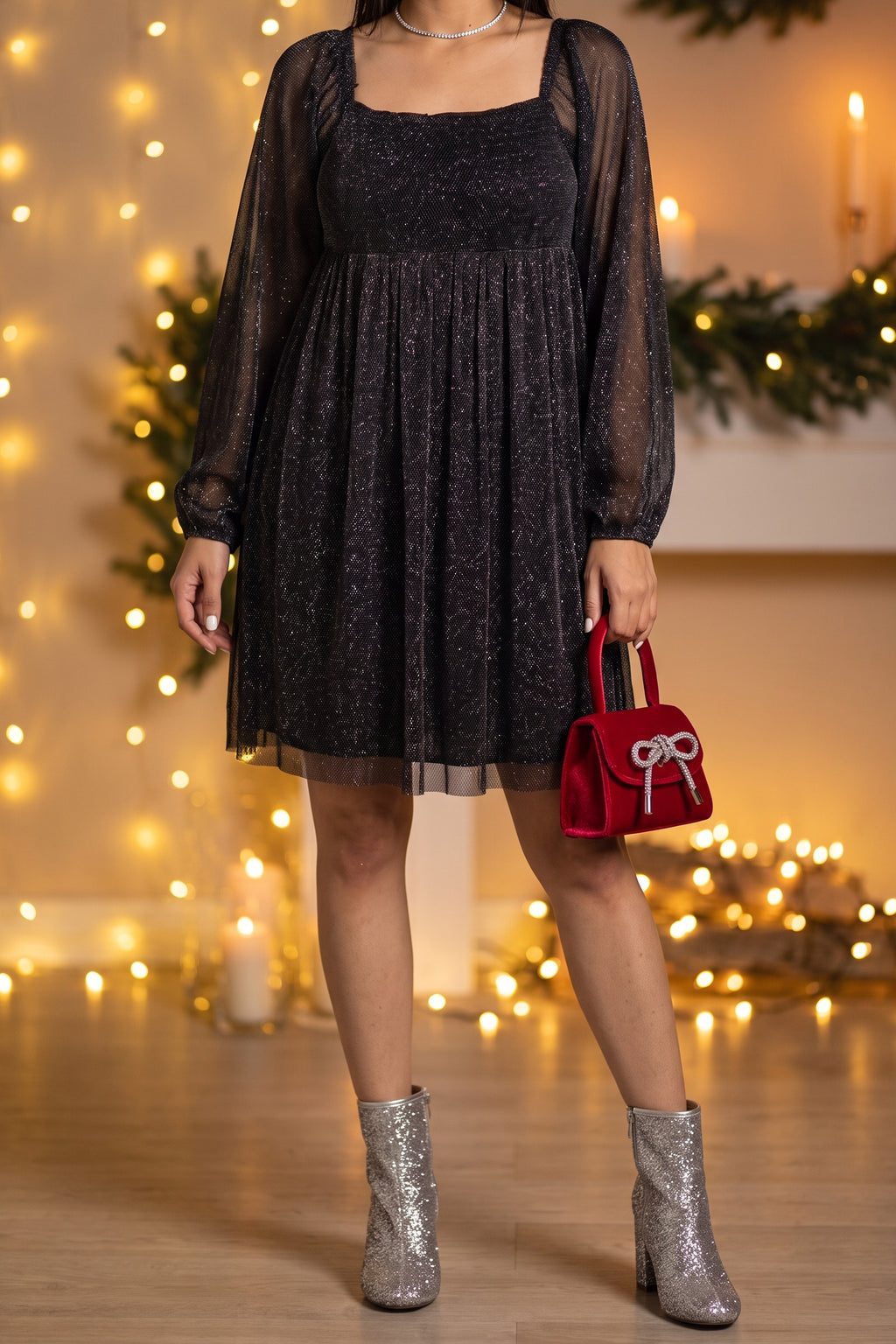 Black glitter babydoll dress styled for a holiday party with silver glitter ankle boots, a red velvet top handle bag and a rhinestone choker.