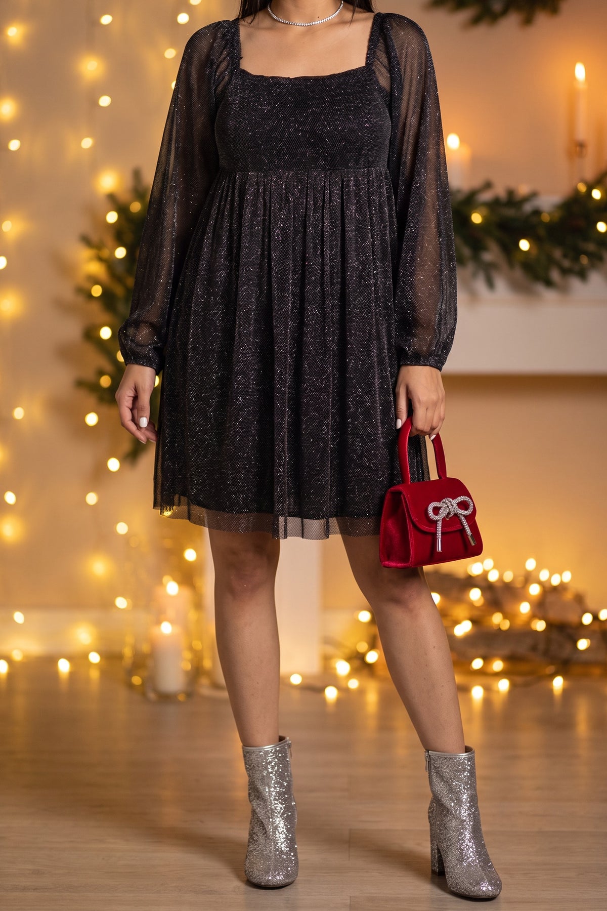 Black glitter babydoll dress styled for a holiday party with silver glitter ankle boots, a red velvet top handle bag and a rhinestone choker.