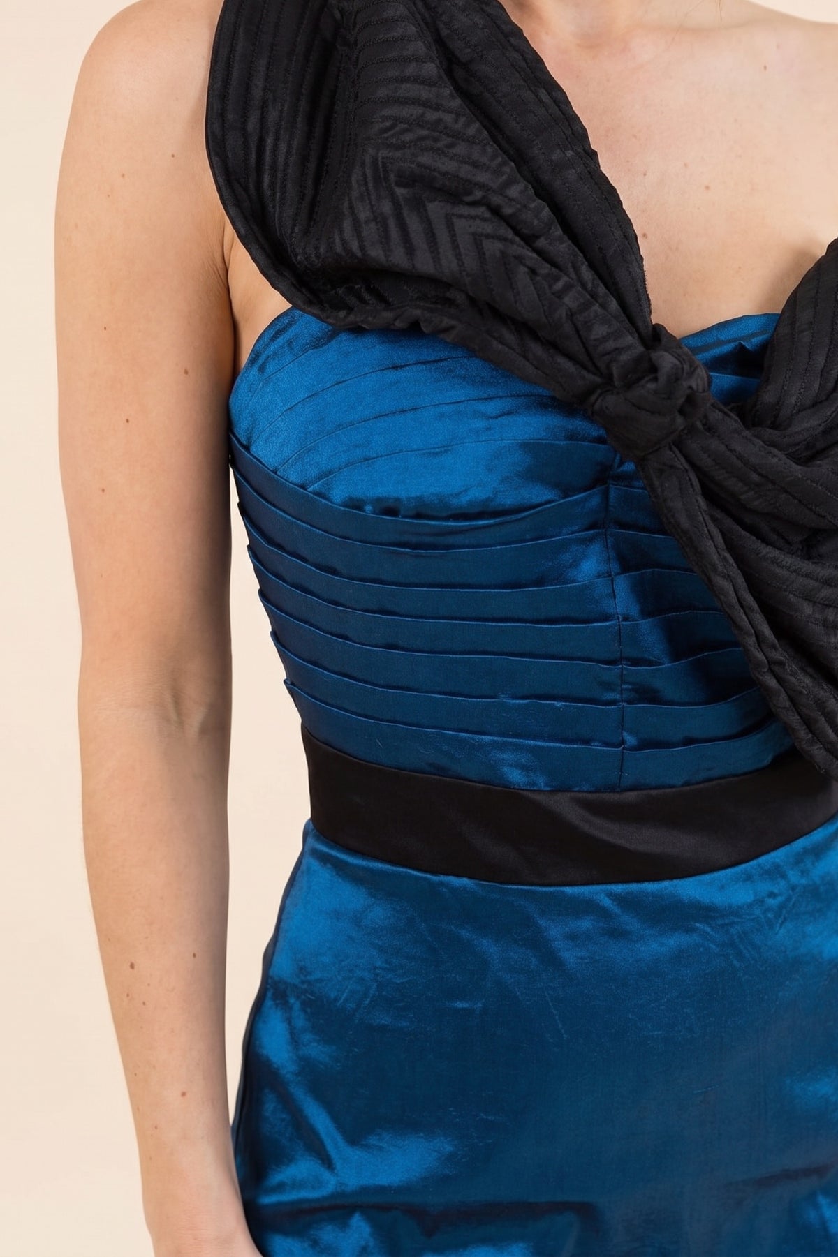Close-up of the oversized black bow, pleated blue satin bodice and black satin waistband on the evening gown.