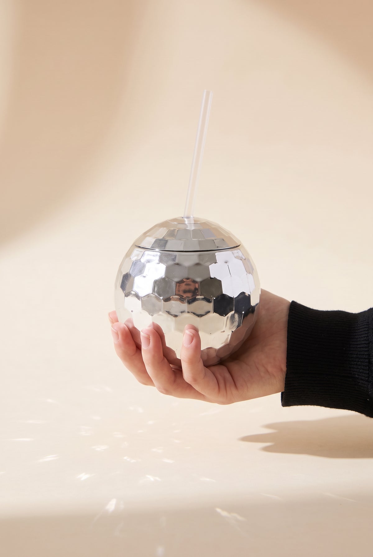 Stella Disco Ball Cup held in one hand, showing its true 4.5 inch grapefruit-sized ball