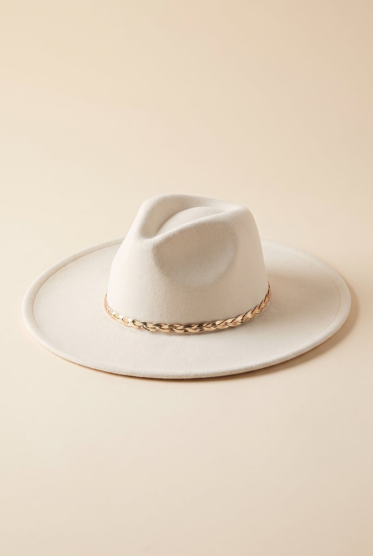 Hadley ivory felt fedora with a braided gold chain band, packshot on cream