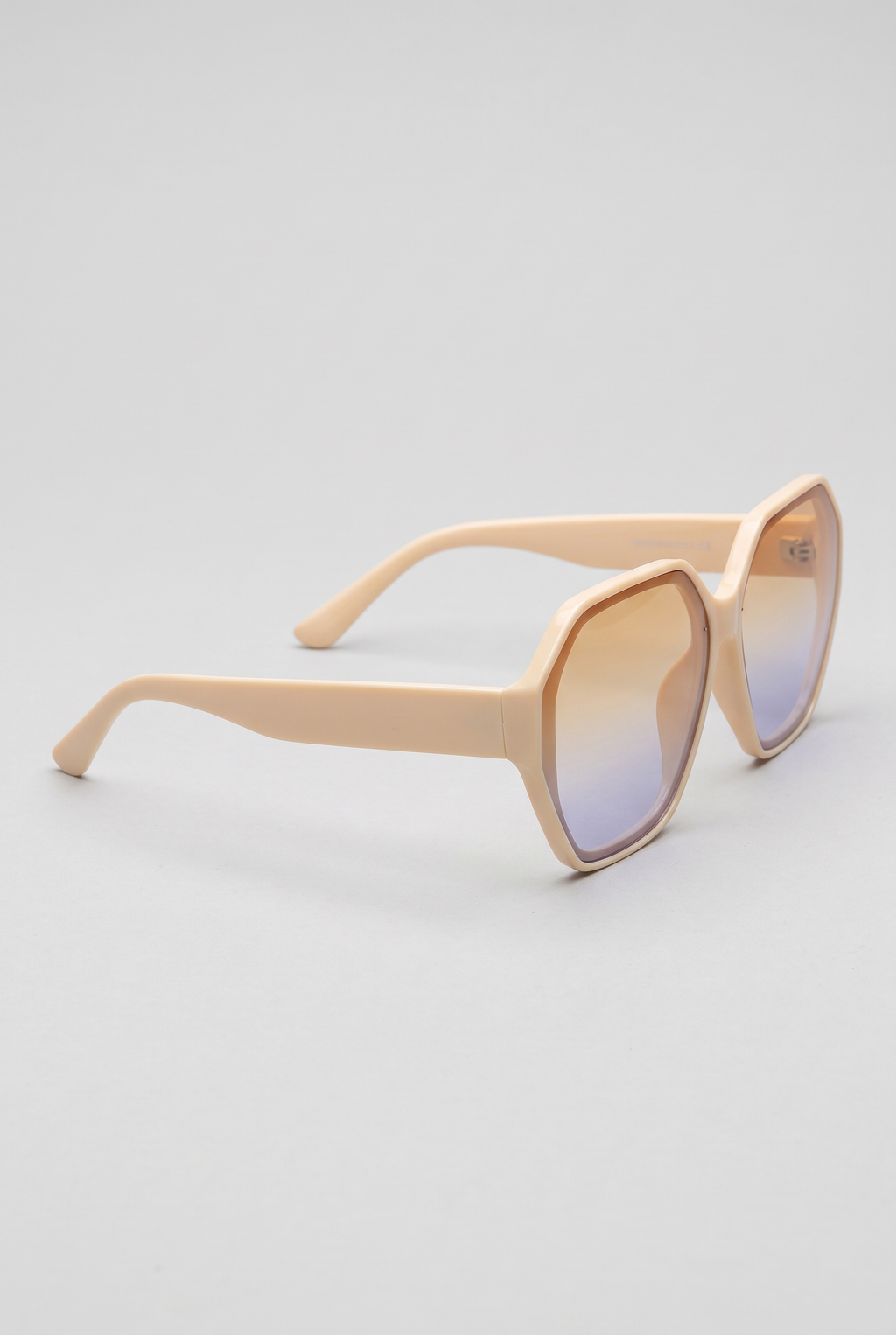 Haven oversized cream sunglasses at a three-quarter side angle showing the temple arm and hinge, on a light-grey backdrop
