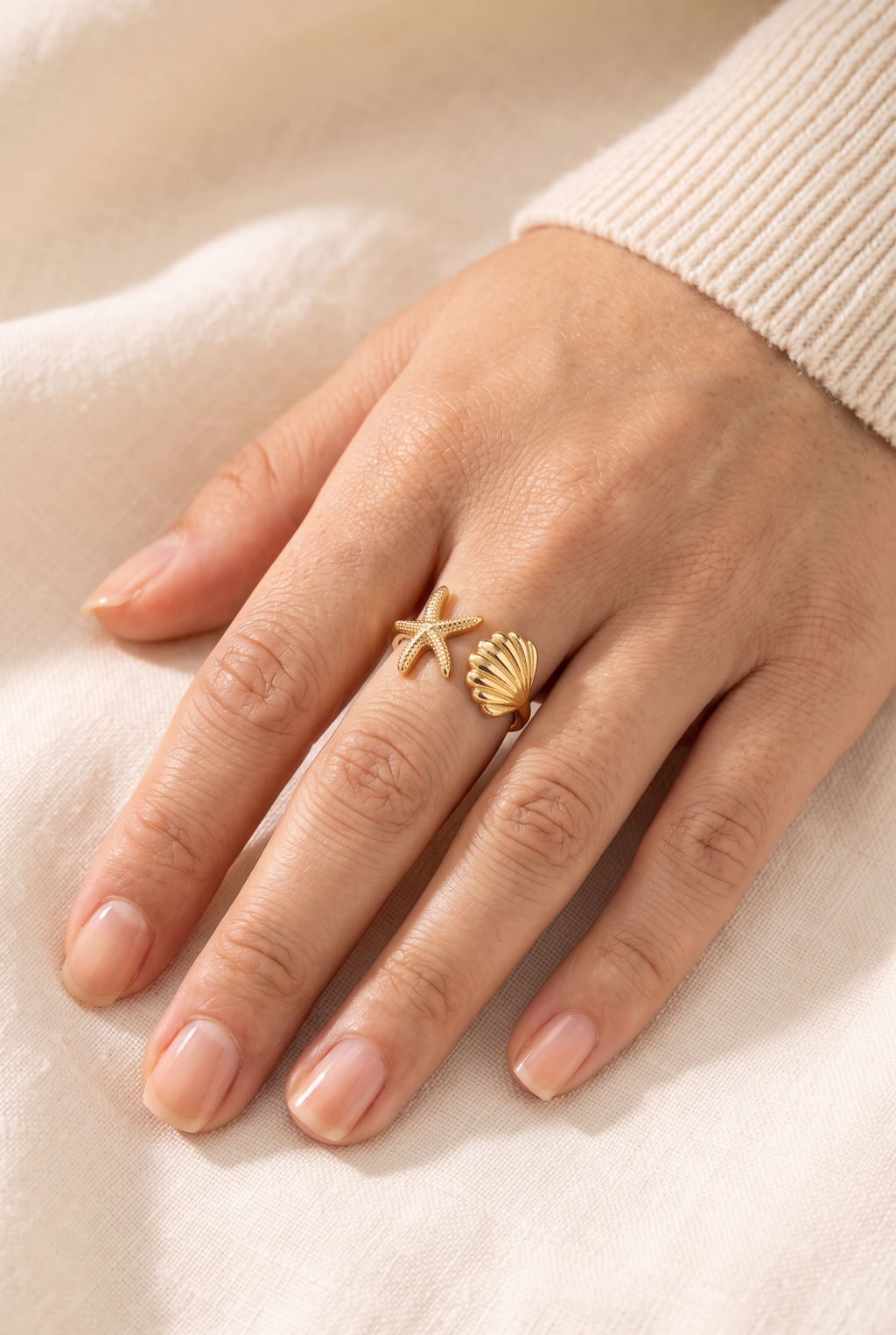 Maria Ocean Treasure Open Wrap Ring Gold worn on one finger, showing its true size: a small starfish and a small scallop shell on a slim gold band