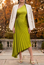 The lime pleated one-shoulder dress at an autumn evening wedding, worn with gold bow sandals, gold fringe earrings and a cream tweed blazer over the shoulders.