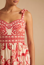 Close-up of the sweetheart neckline, tie strap bow, printed waist border and red scroll print.