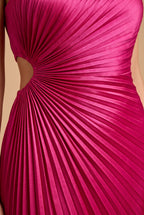 Close detail of the sunburst pleats radiating from the waist cutout on the fuchsia satin.