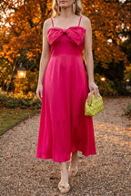 Fuchsia Bow-tiful You Midi Dress styled with gold bow sandals, a lime woven clutch and gold fringe earrings at an autumn garden party