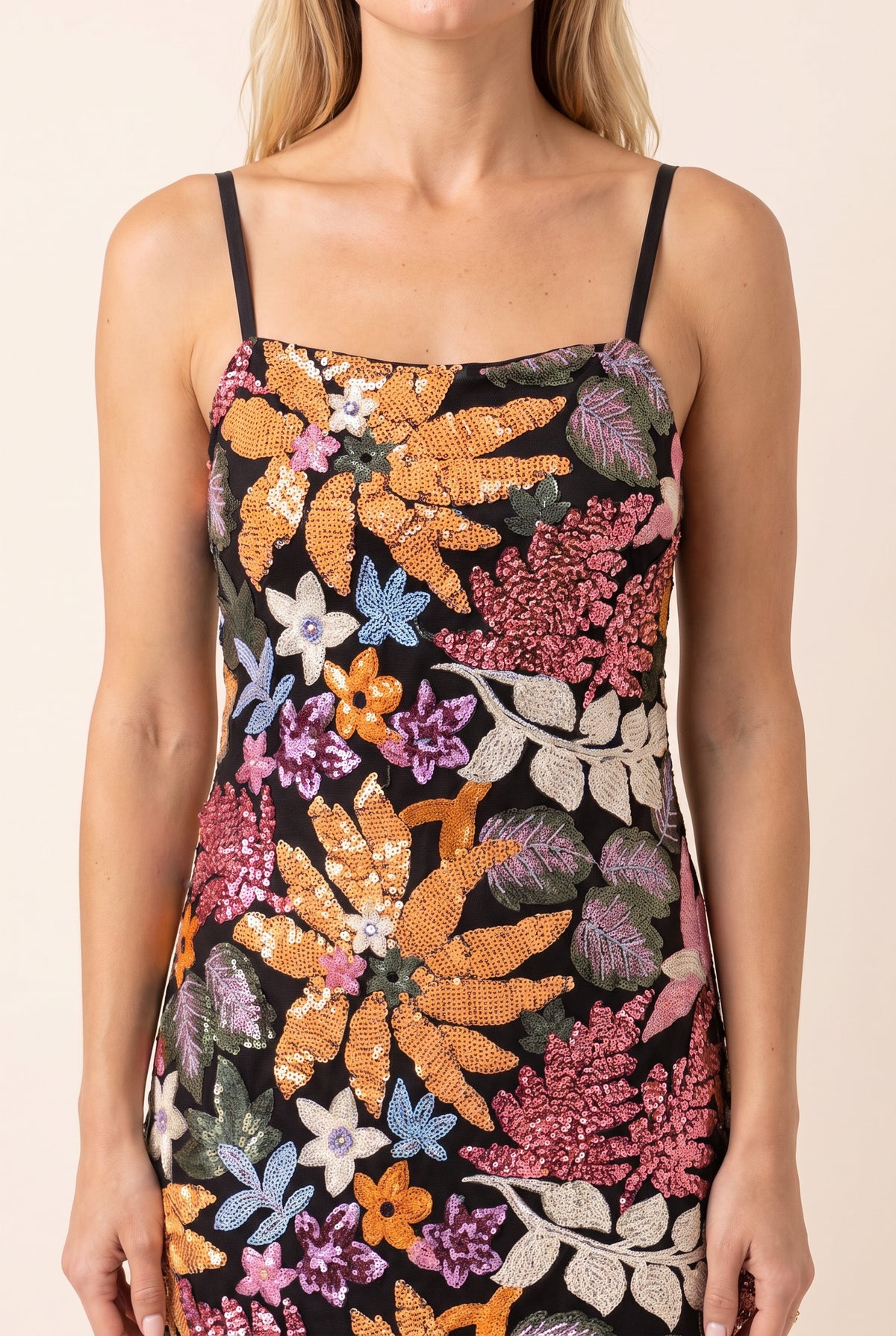 Close view of the sequin and bead florals on the black base, square neckline and thin straps