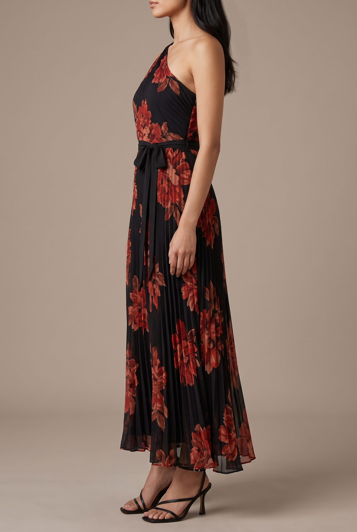 Side of the floral pleated one-shoulder maxi dress showing the front sash bow and the ankle-length pleated skirt.